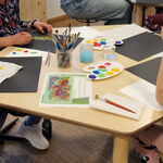 Tisch mit Farbe und bunten Kinderbildern
