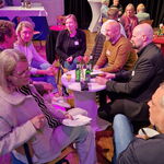 Verschiedene Männer und Frauen sitzen um einen Tisch und sprechen