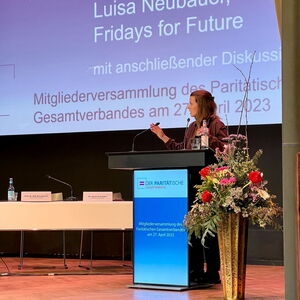 Frau am Pult hät eine Rede (Luisa Neubaer - Fridays for future mit anschließender Diskussion. Mitgliederversammlung des Paritätischen Gesamtverbandes am 27. April 2023)