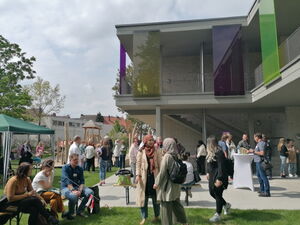 Viele Menschen draußen vor einem Gebäude