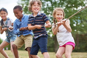4 Kinder unterschiedlicher Hautfarne ziehen an einem Strang