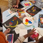 Tisch mit Farbe und bunten Kinderbildern