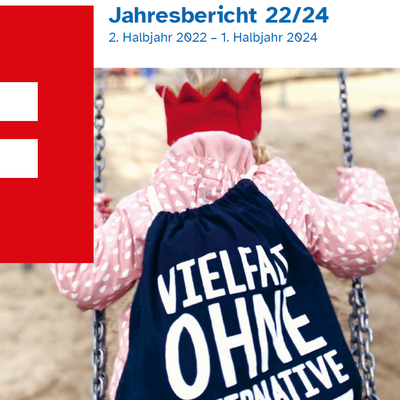 Kind auf Schaukel von hinten, trägt eine rote Krone und einen schwarzen Rucksack mit der Aufschrift Vielfalt ohne Alternative