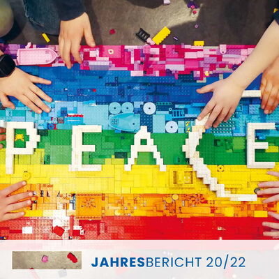 Kinderhände, die aus bunten Legosteinen das Wort PEACE bauen (Jahrebericht 20/22)