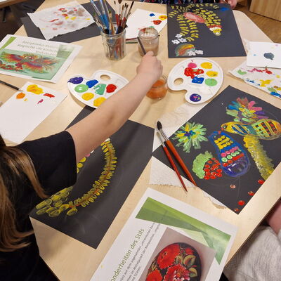 Tisch mit Farbe und bunten Kinderbildern