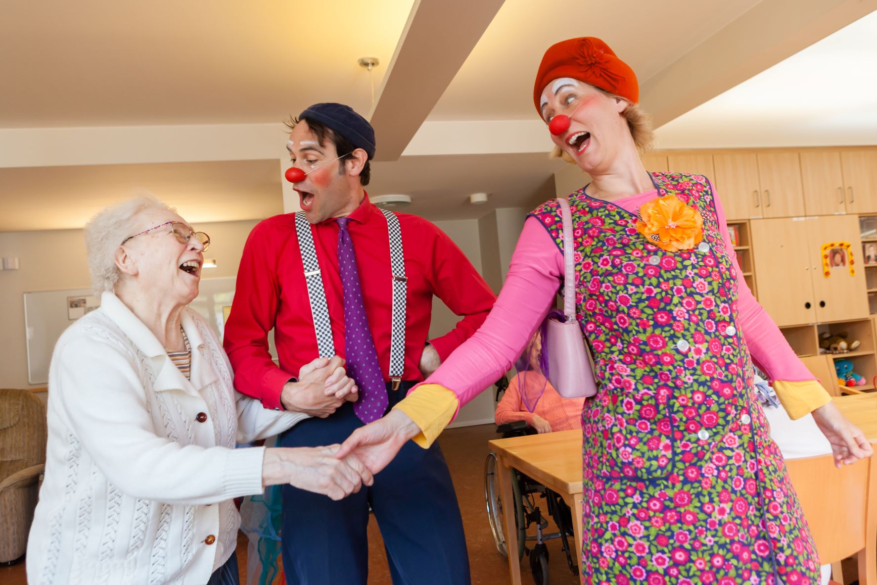 Seniorin mit zwei Clowns
